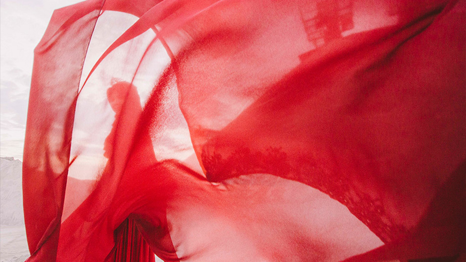 a person with red silk floating in the wind