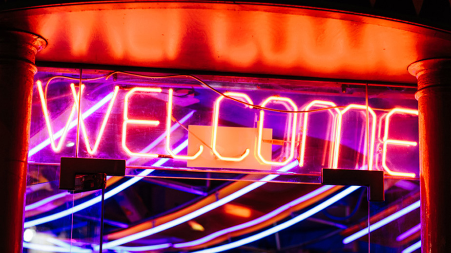 A neon sign that says Welcome