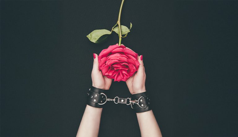 cuffed hands holding a rose