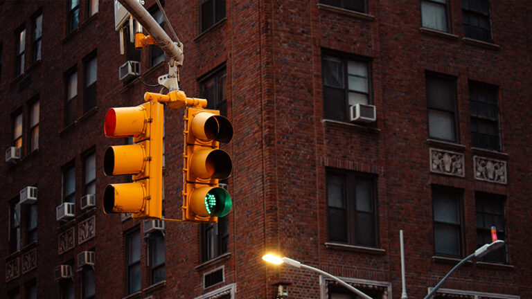 Street lights hanging over an intersection with red and green lit