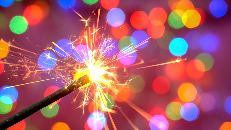 a sparkler with colored lights behind